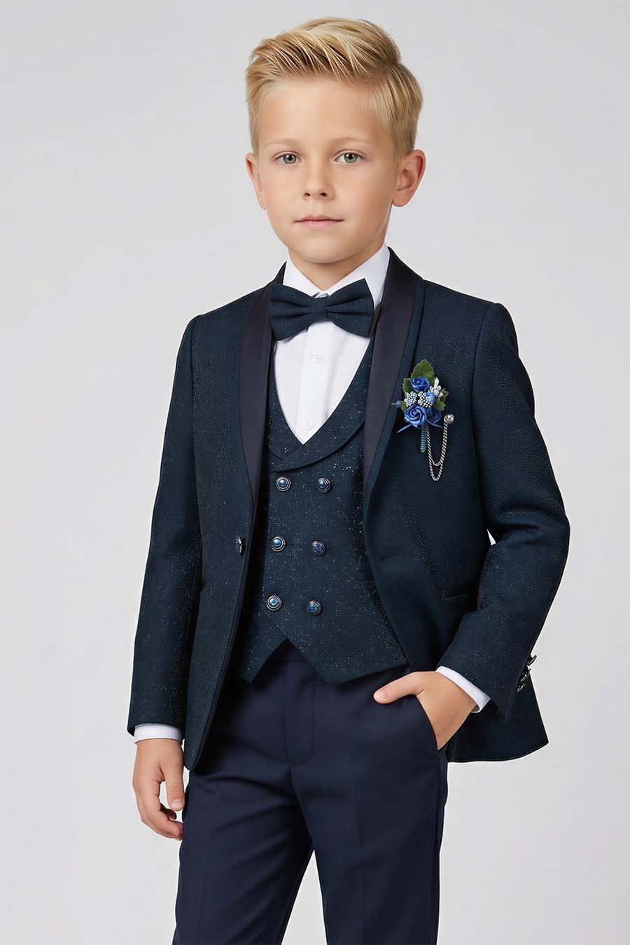 A boy wearing a teal and navy blue brocade suit